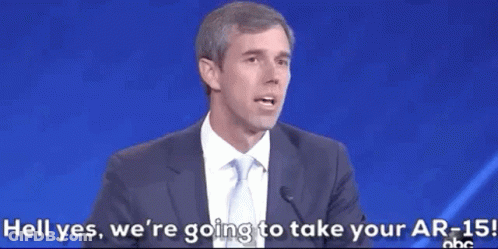 Man In Suit Speaking Into Microphone Says Hell Yes We're Taking Your AR-15 GIF