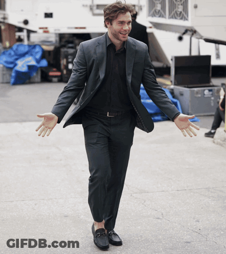 Man In Suit Standing Arms Out GIF