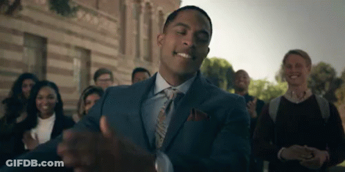Man In Suit Standing Before Applauding Crowd GIF