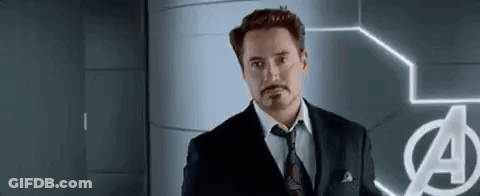 Man In Suit Standing Before Avengers Logo GIF