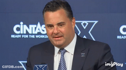 Man In Suit Standing Before Cintas Sign GIF