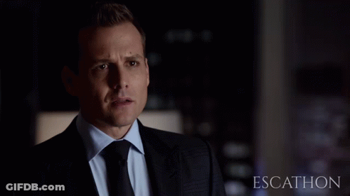 Man In Suit Standing Before Escathon Sign GIF