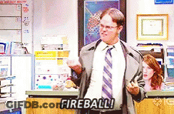 Man In Suit Standing Before Fireball Sign GIF