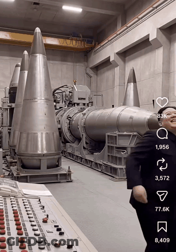 Man In Suit Standing Before Missiles GIF