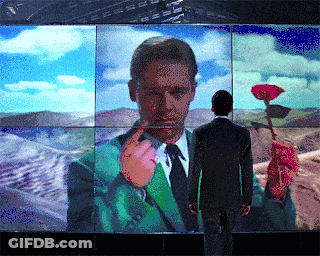 Man In Suit Standing Before Self-Portrait GIF