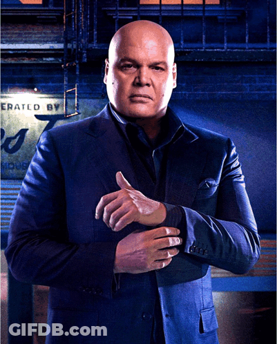 Man In Suit Standing Before Sign GIF
