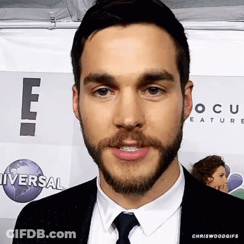 Man In Suit Standing Before Universal Sign GIF
