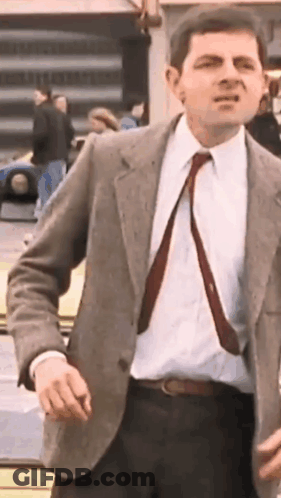 Man In Suit Standing Before Yellow Car GIF