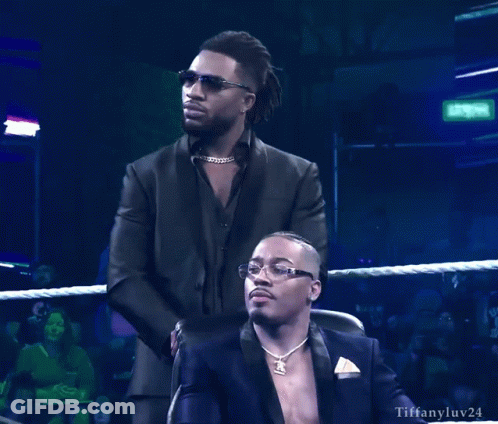 Man In Suit Standing Beside Seated Man Tiffanyluv24 GIF