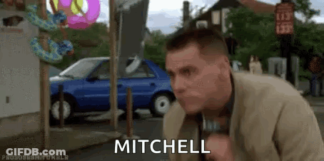 Man In Suit Standing By Blue Car And Donut Shop GIF