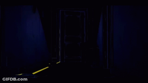 Man In Suit Standing In Dark Hallway GIF