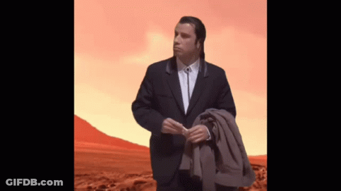 Man In Suit Standing In Desert Holding Jacket GIF