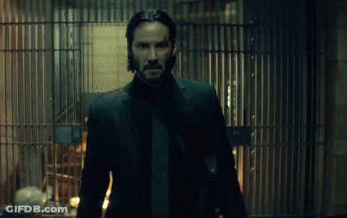 Man In Suit Standing In Front Of Bars GIF
