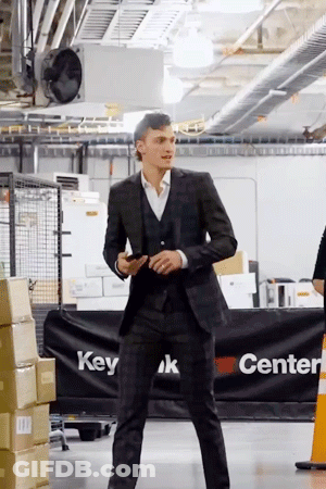 Man In Suit Standing In Front Of Center Sign GIF