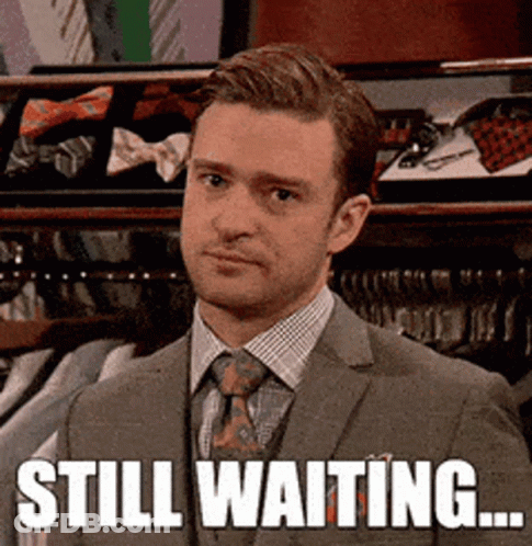 Man In Suit Standing In Front Of Closet Saying Still Waiting GIF