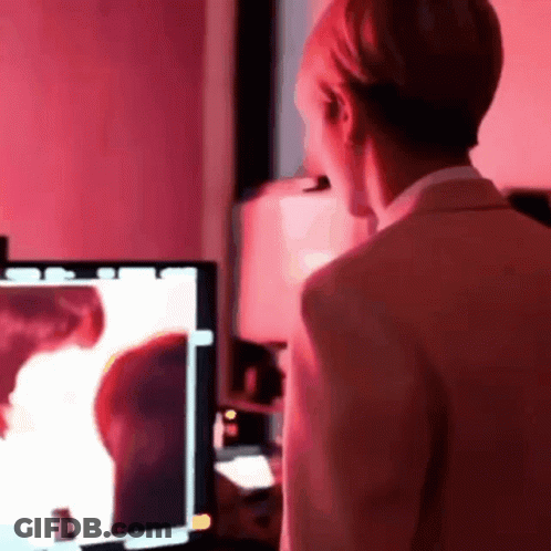 Man In Suit Standing In Front Of Computer Monitor With Red Light GIF