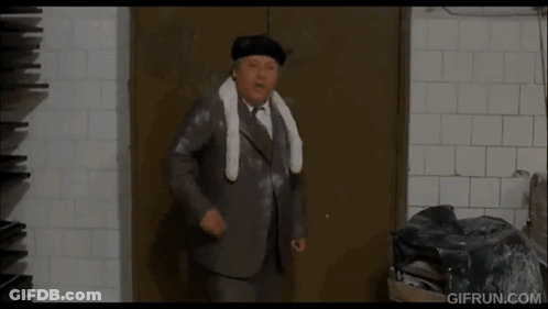 Man In Suit Standing In Front Of Door GIF