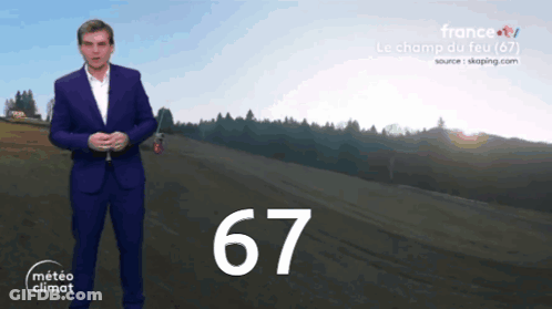 Man In Suit Standing In Front Of Field With Number 67 GIF