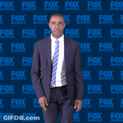 Man In Suit Standing In Front Of Fox Deportes Wall GIF