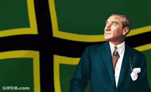 Man In Suit Standing In Front Of Green And Yellow Cross GIF