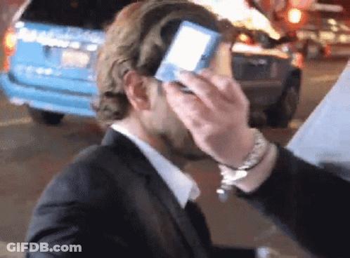 Man In Suit Standing In Front Of Hollywood Awards Screen GIF