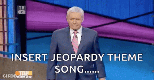 Man In Suit Standing In Front Of Jeopardy Screen GIF