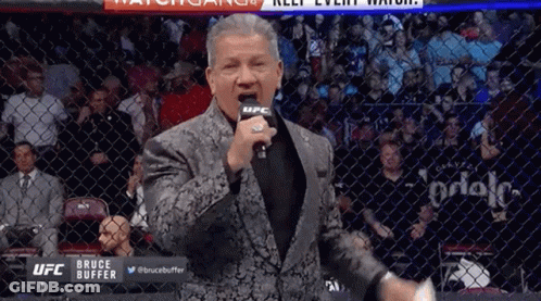 Man In Suit Standing In Front Of Microphone GIF
