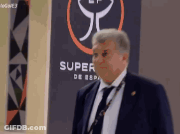 Man In Suit Standing In Front Of Super De Esp Sign GIF