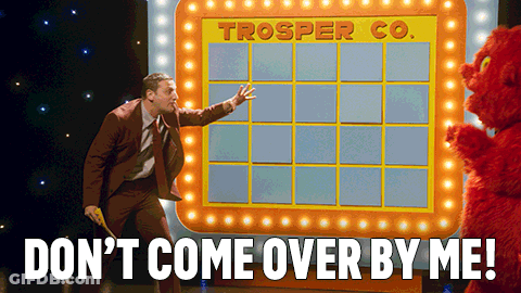 Man In Suit Standing In Front Of Trooper Co. Board GIF