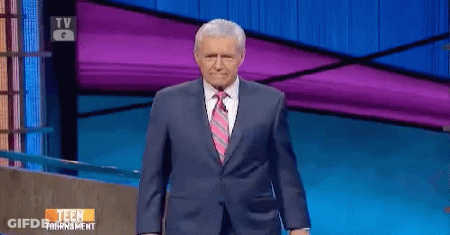 Man In Suit Standing In Front Of TV Saying Teen Tournament GIF
