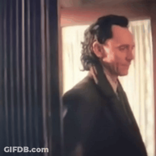 Man In Suit Standing In Front Of Window GIF
