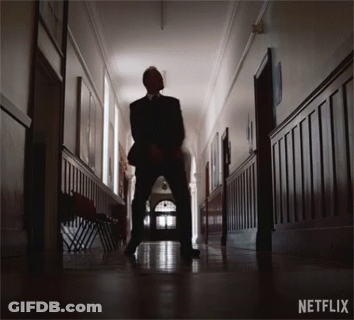 Man In Suit Standing In Hallway With Netflix GIF