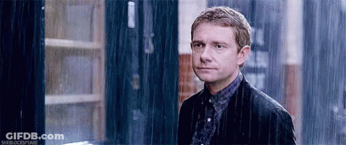 Man In Suit Standing In Rain Looking At Camera GIF
