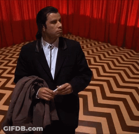 Man In Suit Standing In Room With Zigzag Floor GIF