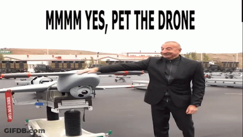 Man In Suit Standing Next To Drone Saying Mmmm Yes Pet The Drone GIF