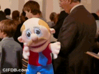 Man In Suit Standing Next To Mustache Toy GIF