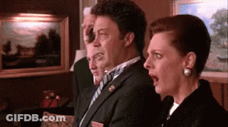 Man In Suit Standing Next To Woman In Black Coat GIF
