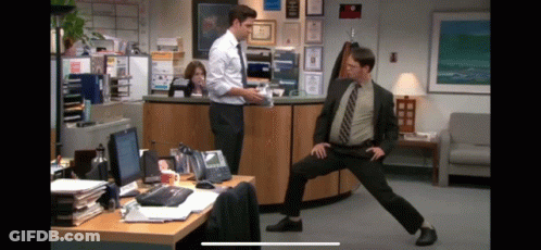 Man In Suit Standing On One Leg In Office GIF