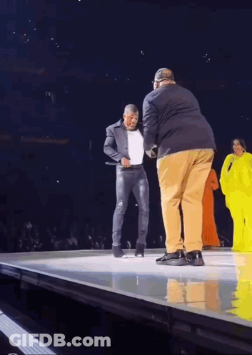 Man In Suit Standing On Stage With Another Man GIF