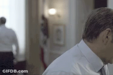 Man In Suit Standing With Woman In Background GIF
