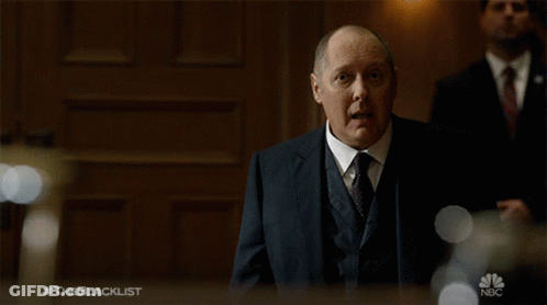 Man In Suit Stands In Front Of The Blacklist Sign GIF