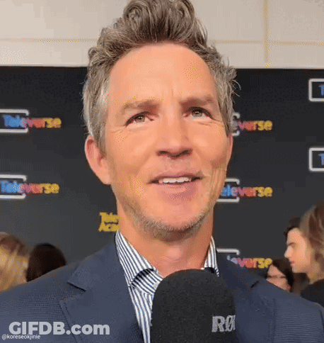 Man In Suit Talking Into Microphone Smiling GIF