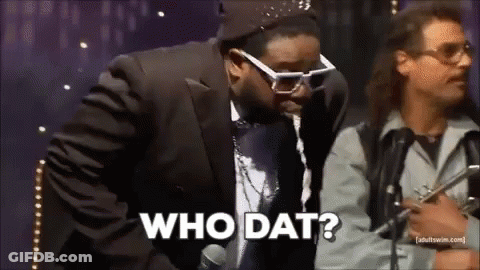 Man In Suit Talking Into Microphone While Another Says Who Dat GIF