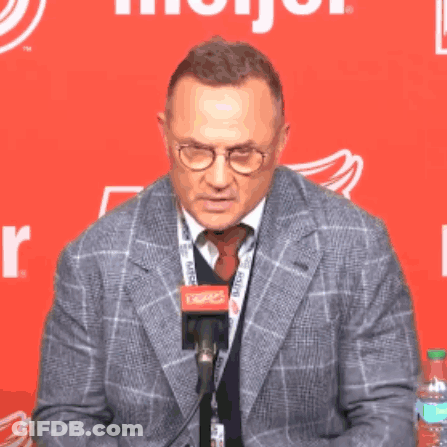 Man In Suit Talking Into Microphone With Glasses GIF