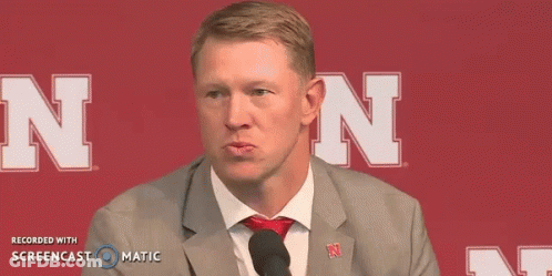 Man In Suit Talking Into Microphone With Letter N GIF
