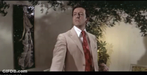 Man In Suit Talking Into Microphone With Letter N GIF