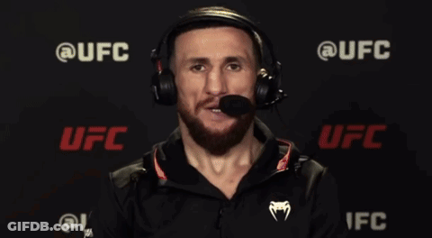 Man In Suit Talking Into Microphone With UFC Logo GIF