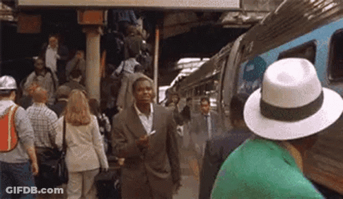 Man In Suit Talking On Cell Phone By Train GIF