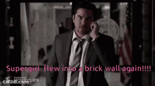 Man In Suit Talking On Cell Phone Says Supergirl Flew Into Brick Wall Again GIF