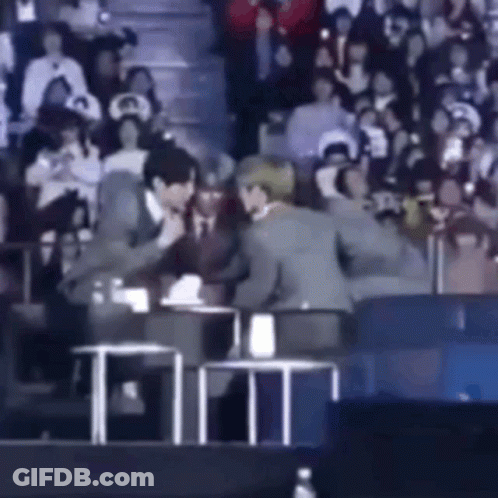 Man In Suit Talking To Another In Crowd GIF